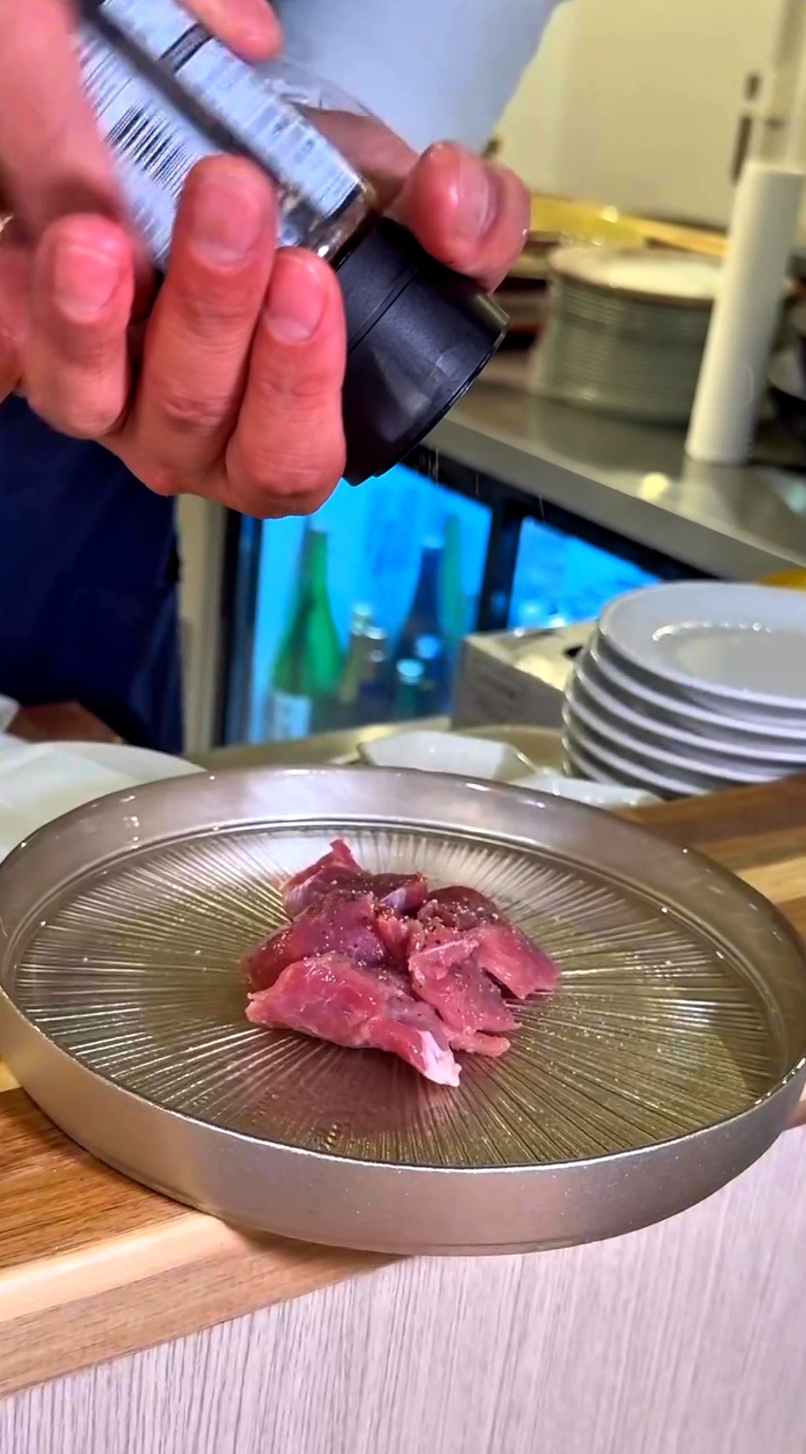 店主が生ラムに黒胡椒をふっているところ