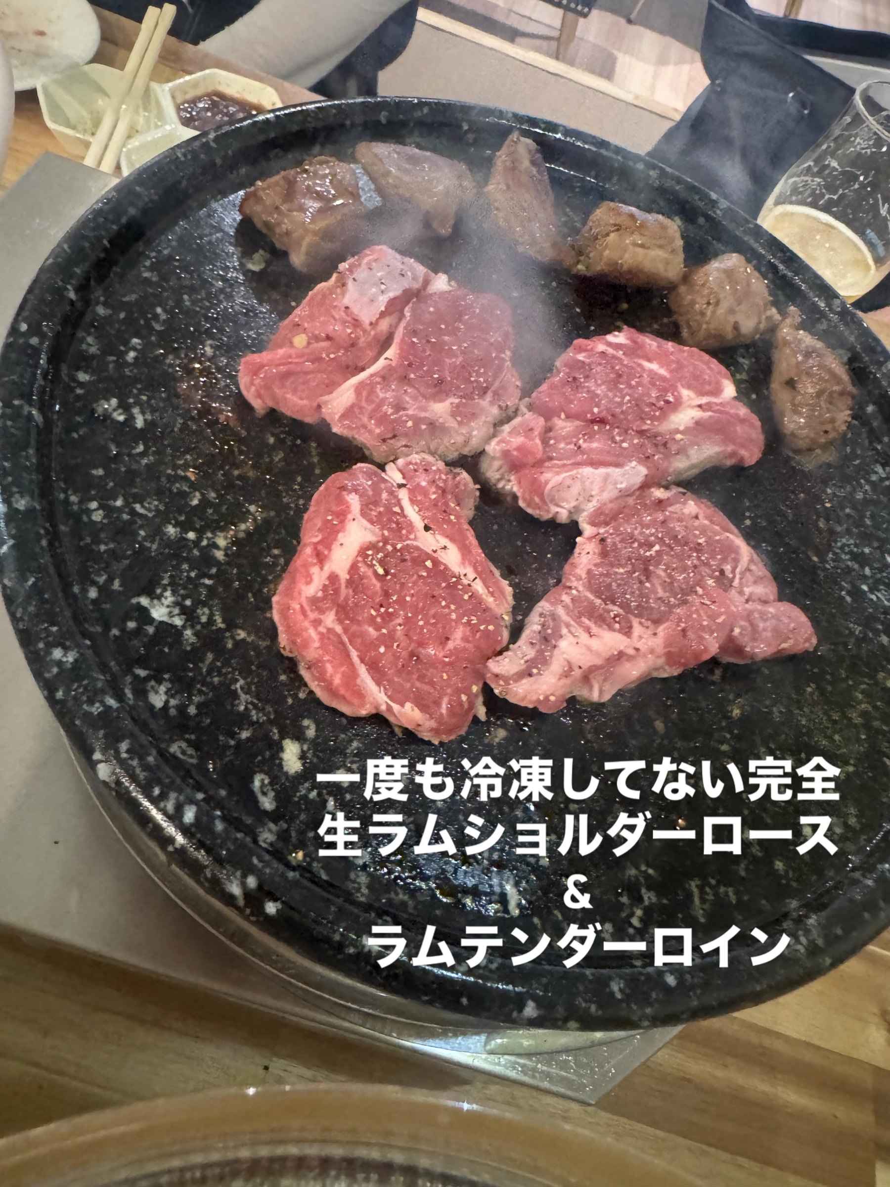 黒い陶板で焼いている生ラムのショルダーロースとテンダーロイン